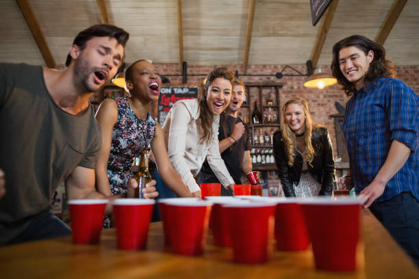 istock Young friends playing beer pong game in bar 677945072