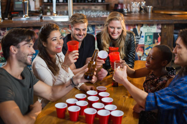 istock Happy friends drinking beer while sitting around disposable cups in bar 677945382