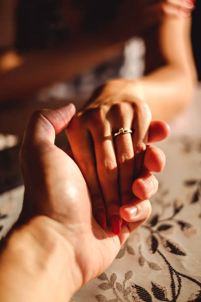 istock Man holding woman's hand with wedding ring on the finger 677970664