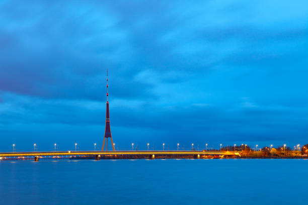 vue de riga tv tour et pont illumunated nuit, lettonie - illumunated photos et images de collection