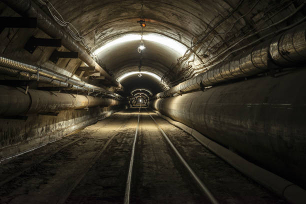 istock A tunnel with pipes and a railroad lighted by a dull light 677977670