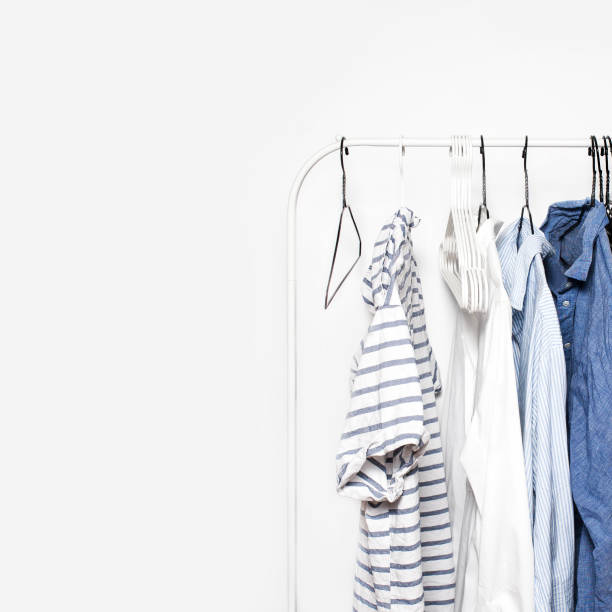 istock Stripped Clothes on a  Rack  over white Wall Background close up with copyspace. Blue, White 678025046