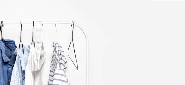 istock Stripped Clothes on a  Rack  over white Wall Background close up with copyspace. Blue, White 678025064