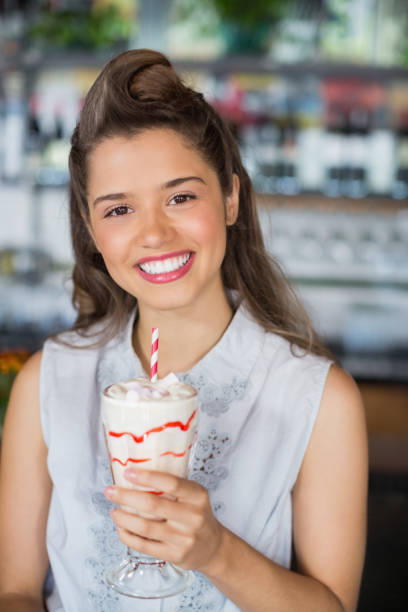 istock Young woman drinking smoothie at restaurant 678038958