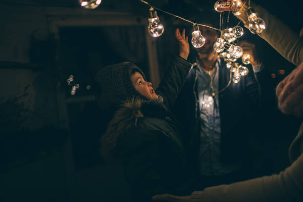Young family decorating terrace of their apartment in winter night