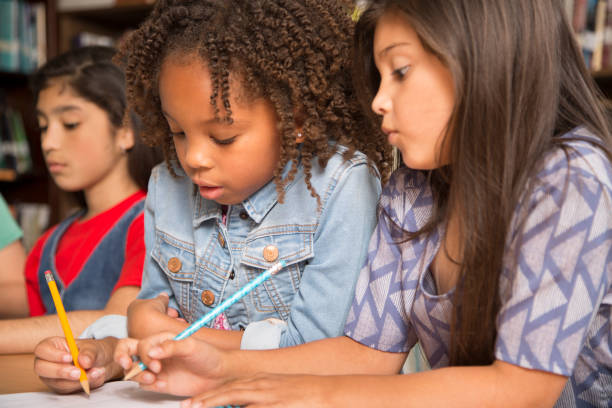 istock Elementary-age school girls collaborate on homework. 678074494