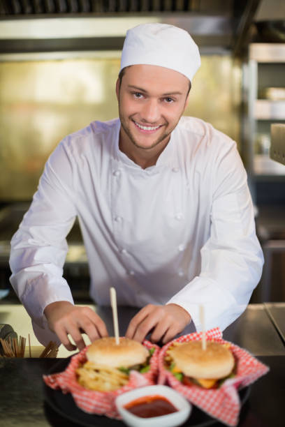 istock Male chef preparing burger in commercial kitchen 678078484