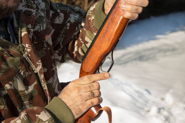 istock Man's hands holding a flask with a long gun hunting. 678080042