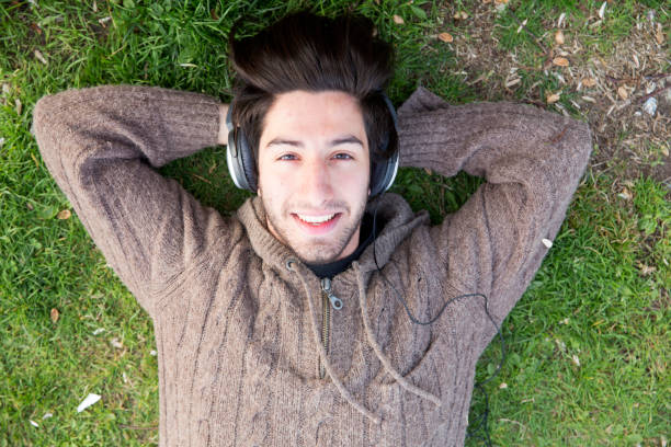 istock Young man listenning music on the grass 678097966
