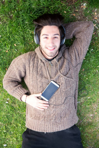 istock Young man listenning music on the grass 678102050