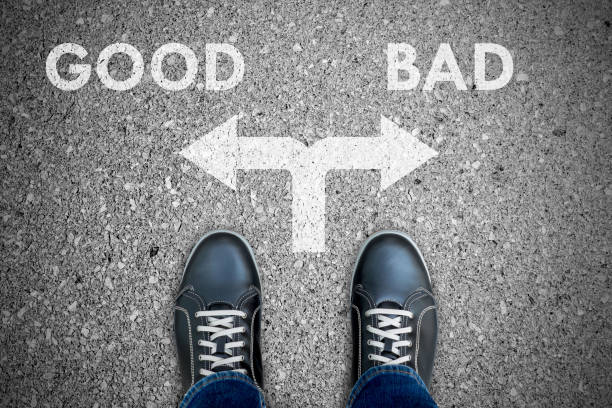 Black casual shoes making decision - good or bad Black casual shoes standing at the crossroad making decision good or bad. negative emotion stock pictures, royalty-free photos & images