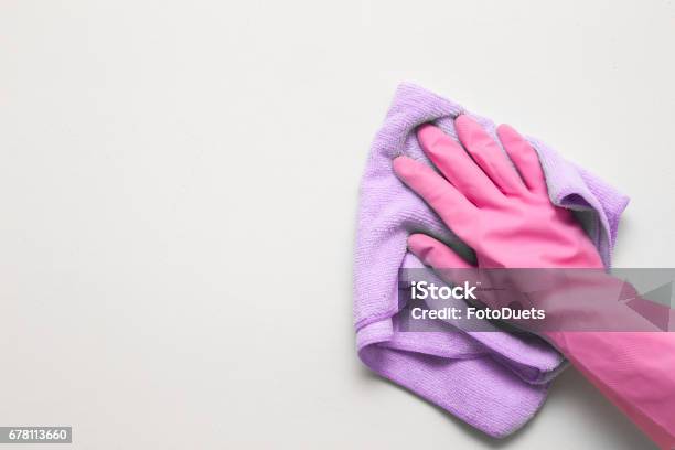 Womans Hand In Pink Rubber Protective Glove Wiping White Wall From Dust With Dry Rag Early Spring Cleaning Or Regular Clean Up Maid Cleans House Stock Photo - Download Image Now