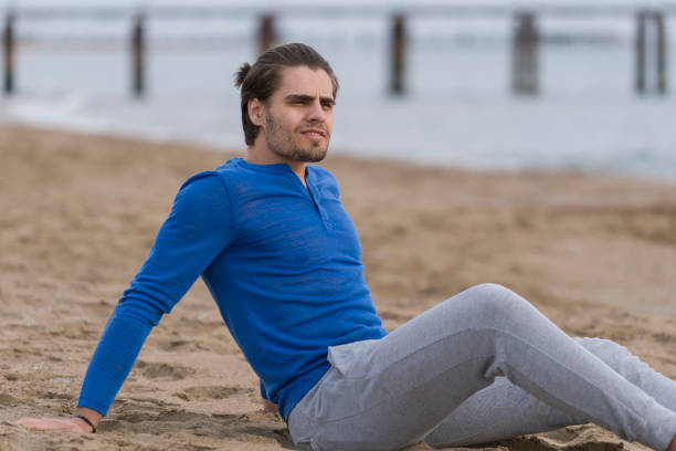 istock Handsome  man sitting alone at the beach 678127388