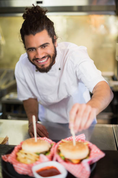 istock Male chef preparing burger in commercial kitchen 678127510