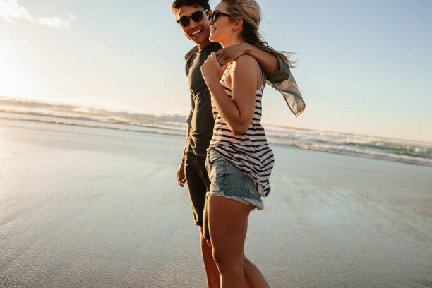 istock Romantic young couple strolling on the beach 678128086