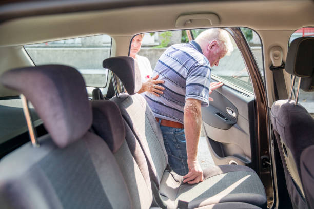 Nurse Helping Senior Man to get in the Car