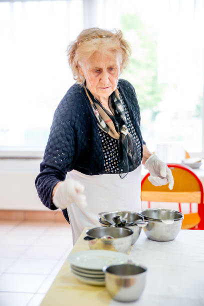 istock Senior Woman Preparing Tables for the Breakfast 678130280