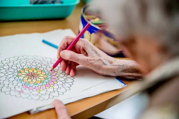 Senior Woman Coloring Mandala at the elderly daycare center - Coloring design was created for the shooting.