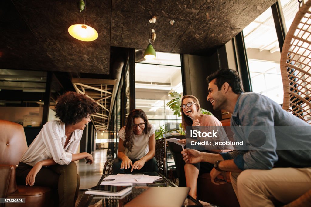 Team of corporate professionals having friendly discussion Team of corporate professionals having friendly discussion in a meeting. Multi ethnic business team having project discussion. Fun Stock Photo