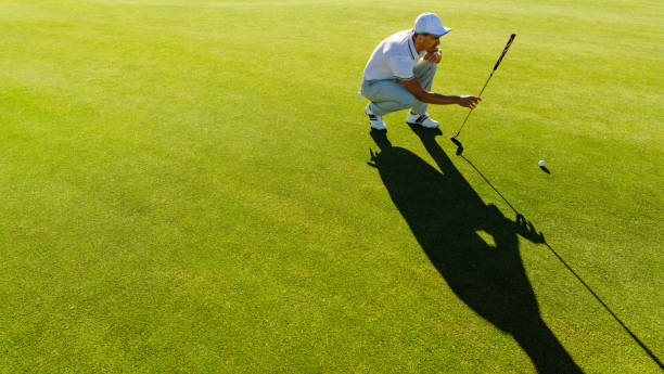 istock Golfer checking line for putting golf ball 678132610