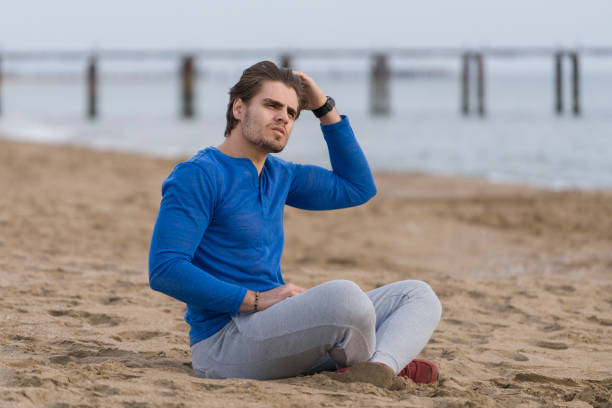 istock Handsome  man sitting alone at the beach 678147536
