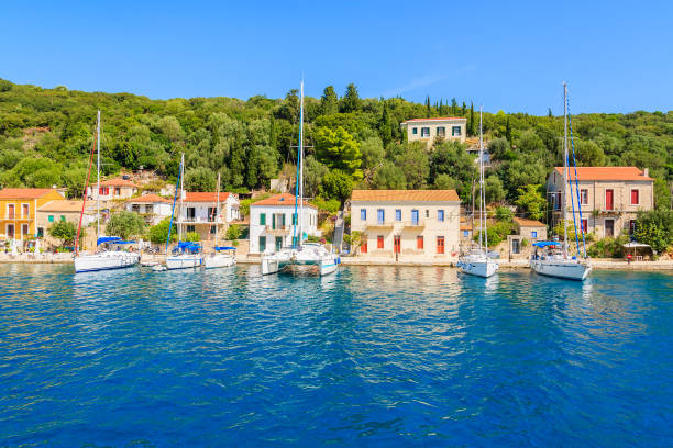 View of colourful houses and sailing boats in Kioni port on Ithaca island, Greece Kefalonia is a Greek island in Ionian Sea. It is the largest of Ionian islands and the sixth largest Greek island. ithaca stock pictures, royalty-free photos & images
