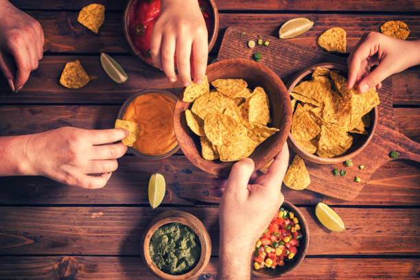 familia comiendo nachos con salsas - patatas fritas tentempié fotografías e imágenes de stock