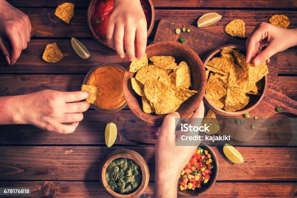 Family Eating Nachos With Sauces Stock Photo - Download Image Now - Snack, Potato Chip, Tortilla Chip