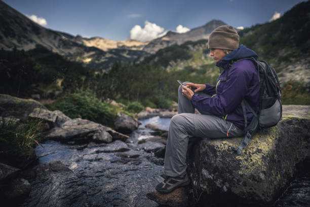 istock Traveler using a smartphone in the mountains 678181706
