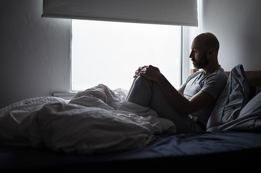 Man in bed suffering from mental illness