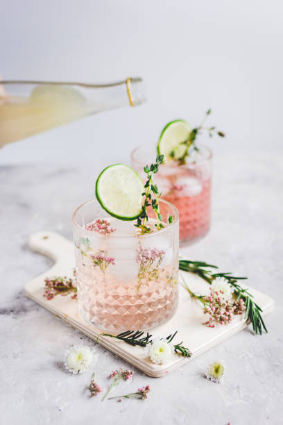 istock pink fresh cocktail with flowers and cut lime on stone desk background 678219638