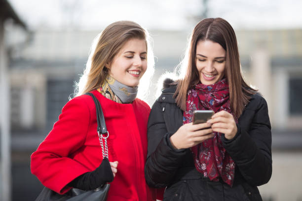 istock Two happy woman looking at smartphone and laughing 678259364
