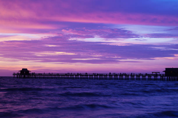 Sunset at naples beach florida - fishing pier in the background