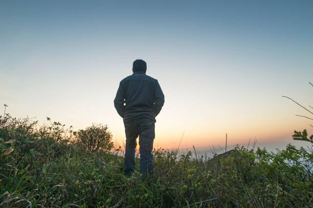 istock man standing in bush on mountain near sunset 678259762