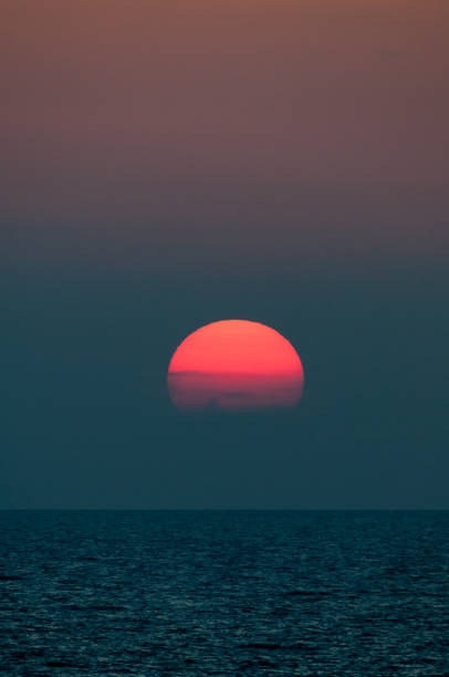 istock Bright red sunset setting in the sea 678273514