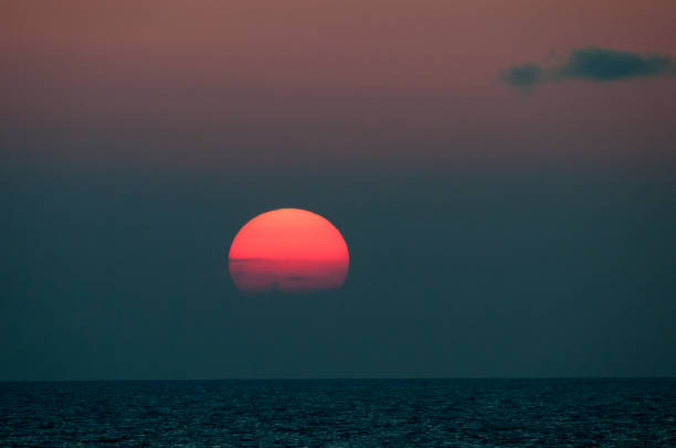 istock Bright red sunset setting in the sea 678276192
