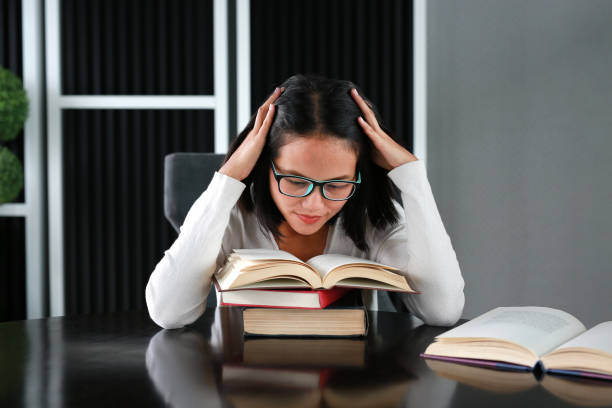 istock Asian woman under pressure reading a book in the library. 678276408