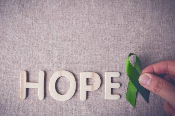 finger lime green ribbon mit hölzernen wort hoffnung, lyme krankheit, psychische gesundheitsbewusstsein halten - hodgkins disease stock-fotos und bilder