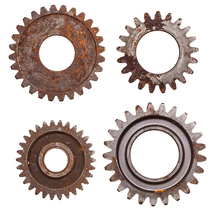 Four rusty gears isolated on a white background.