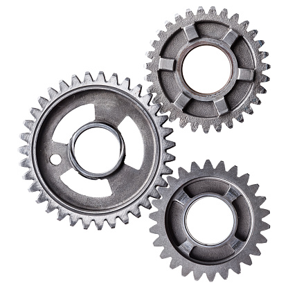 A cluster of interlocking metal gears isolated on a white background.