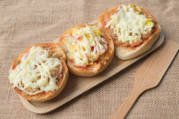 istock Fresh mini buns topped with pizza on wooden tray 678337528