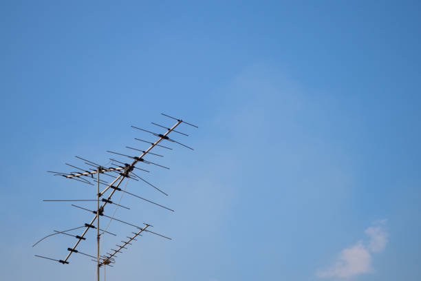 Television antenna on blue sky background at daytime