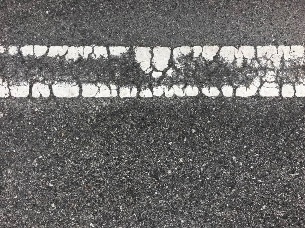 istock Crack white line on asphalt road texture 678388636