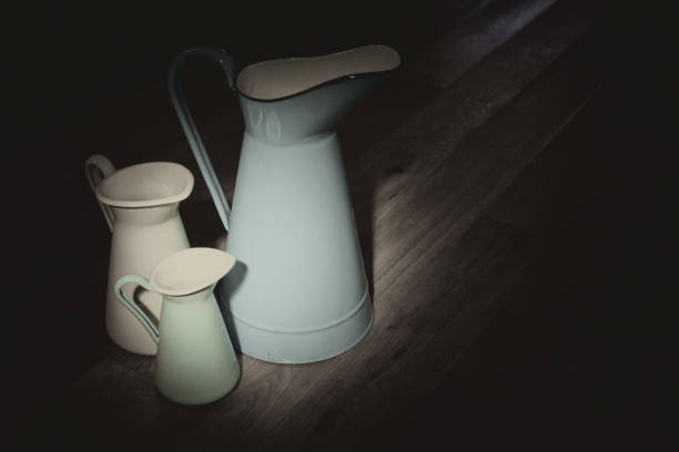 istock Antique pitchers with moody lighting 678389834