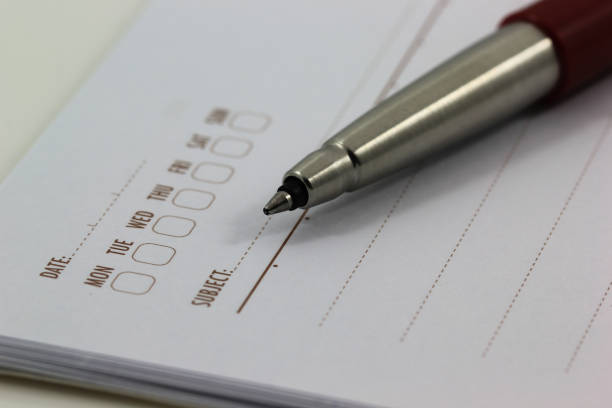 istock selective focus of the ball pen on opened lined diary book 678402244