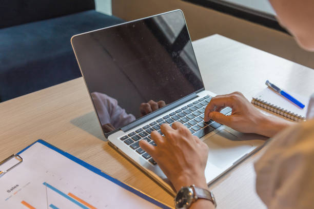 istock Rear view of human hands typing laptop at workplace 678406720