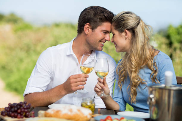 istock Smiling couple toasting wineglasses at table 678413122