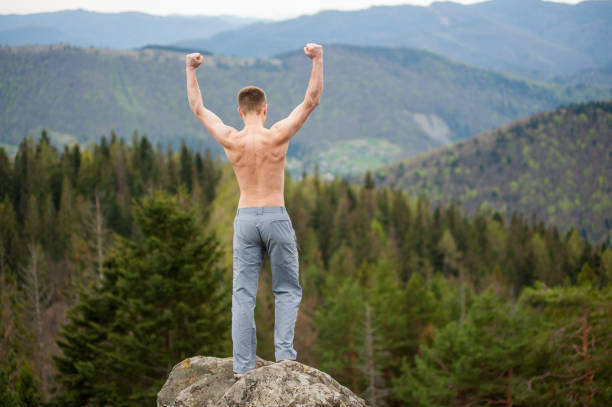 istock Male climber with brown backpack on the peak of rock 678413434