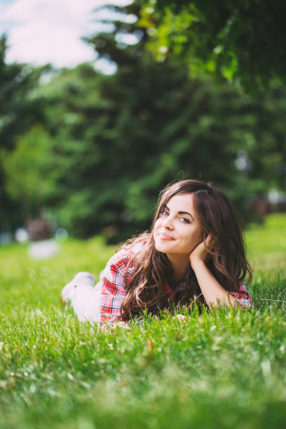 istock Beautiful woman lying on green grass 678422328