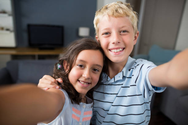 istock Siblings taking selfie in living room 678440974